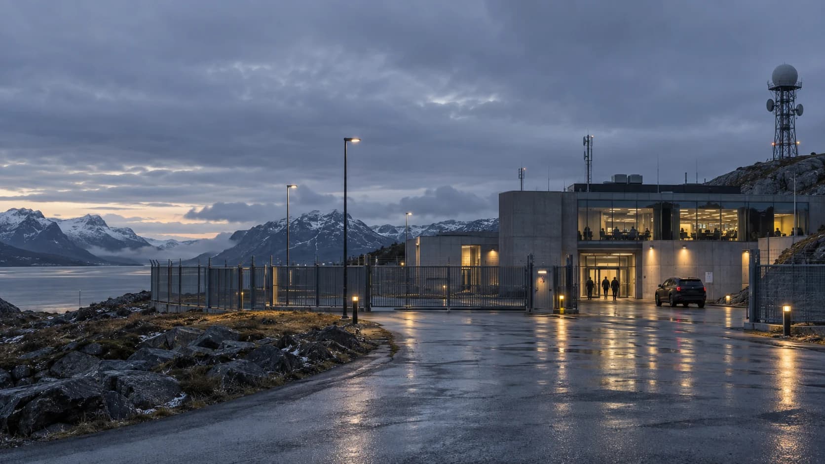 A protected coastal facility at dusk with communications equipment and a staffed entrance.